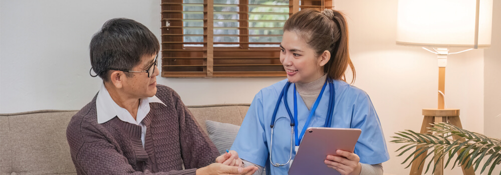 Cuidadora de idosos auxiliando idosa a escrever